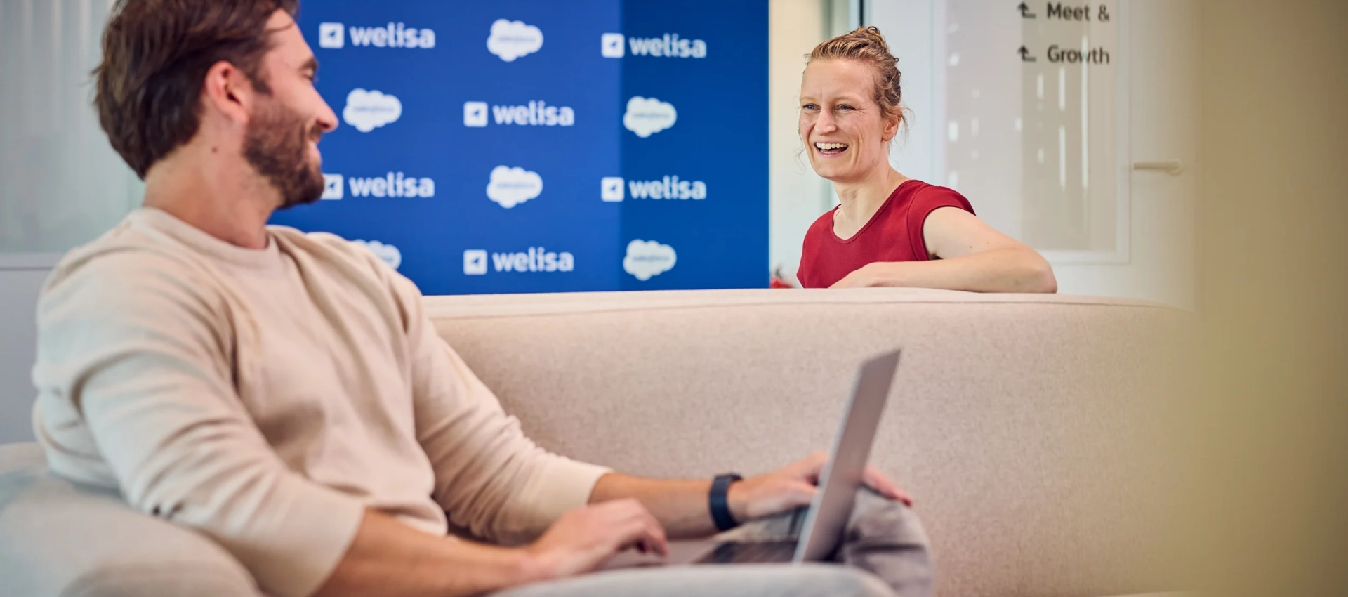 Salesforce marketing cloud consultants lachen naar elkaar op de bank