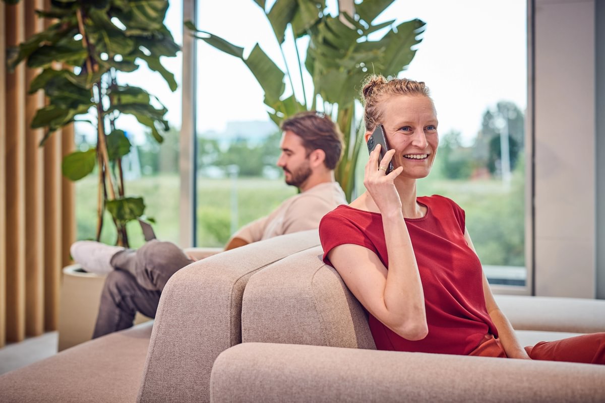 Vrouw zit bellend op een bank