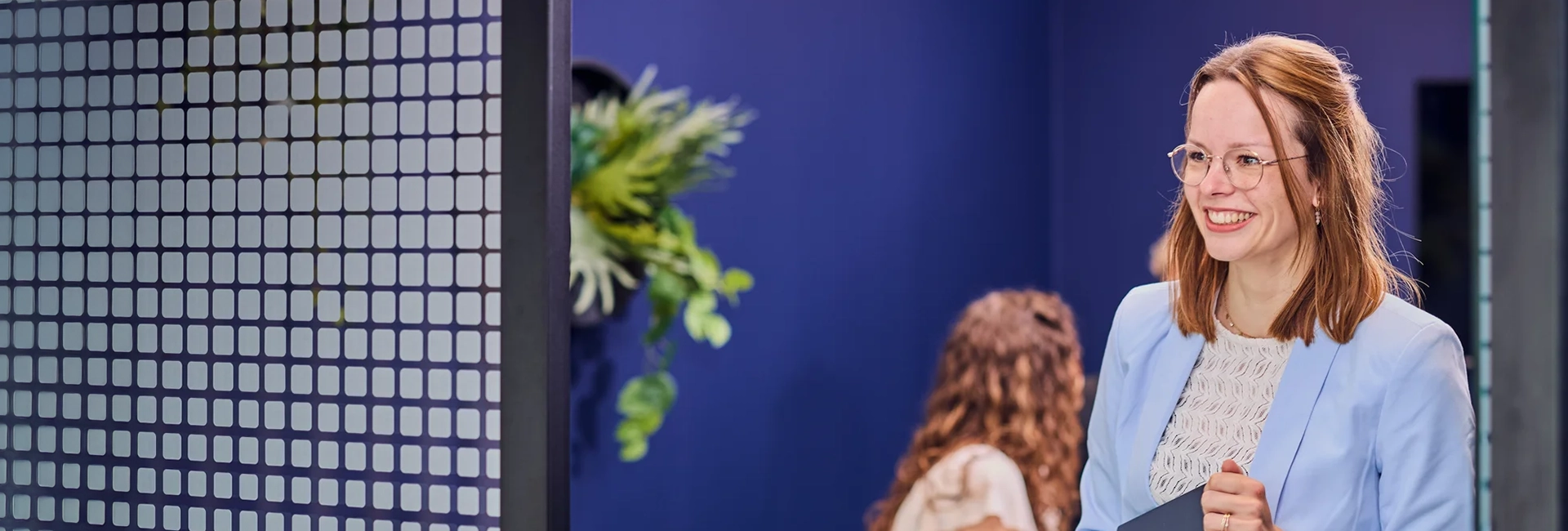 Salesforce consultancy partner staat in de deuropening met haar laptop in haar handen.